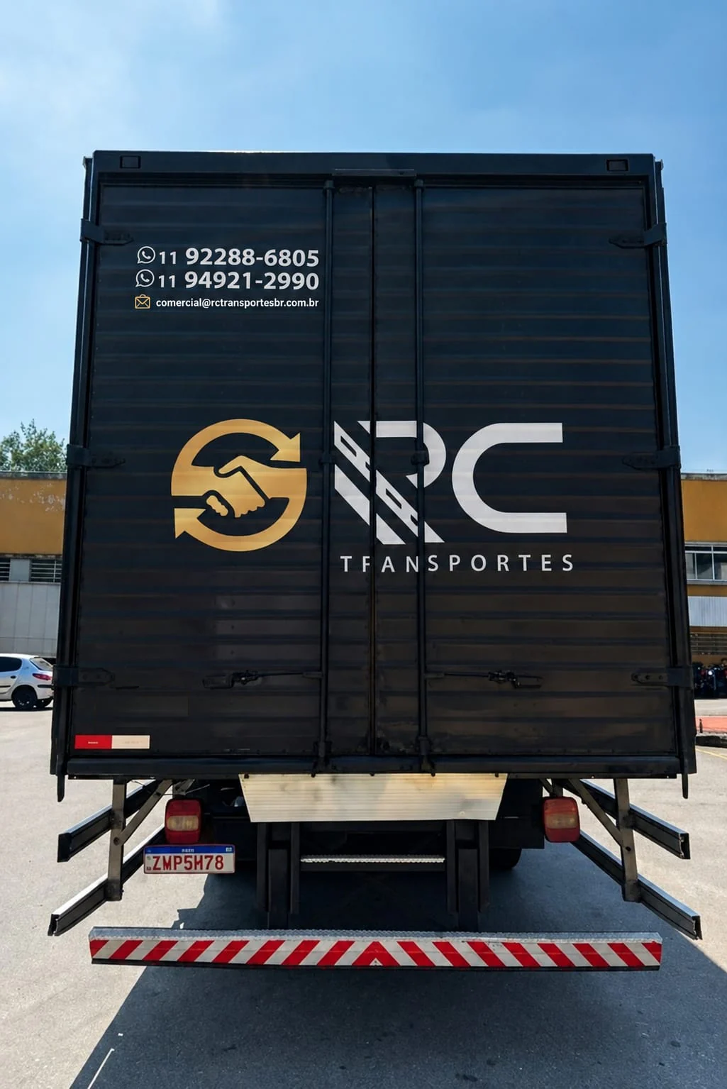 Traseira do baú da RC Transportes com logotipo e contatos